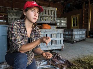 
                Student in the barn with produce
            