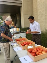 Mahfuz Rahman, left, slices a tomato so guests can do some taste testing. 