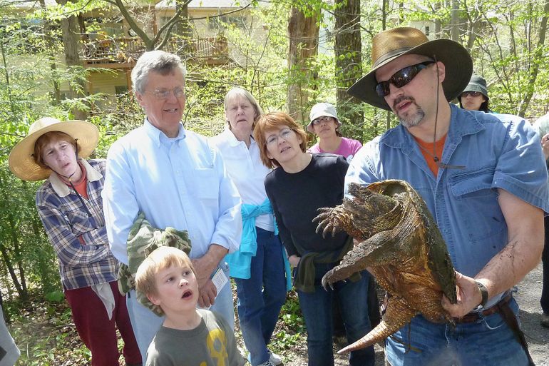 Jim Anderson showing a snapping turtle to a crowd of people