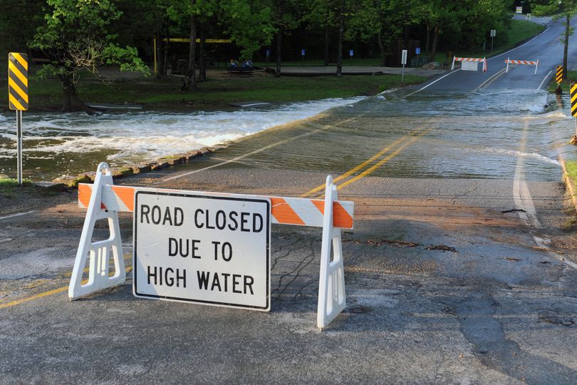 A "road closed" sign blocks off a two-lane highway due to flooding in West Virginia