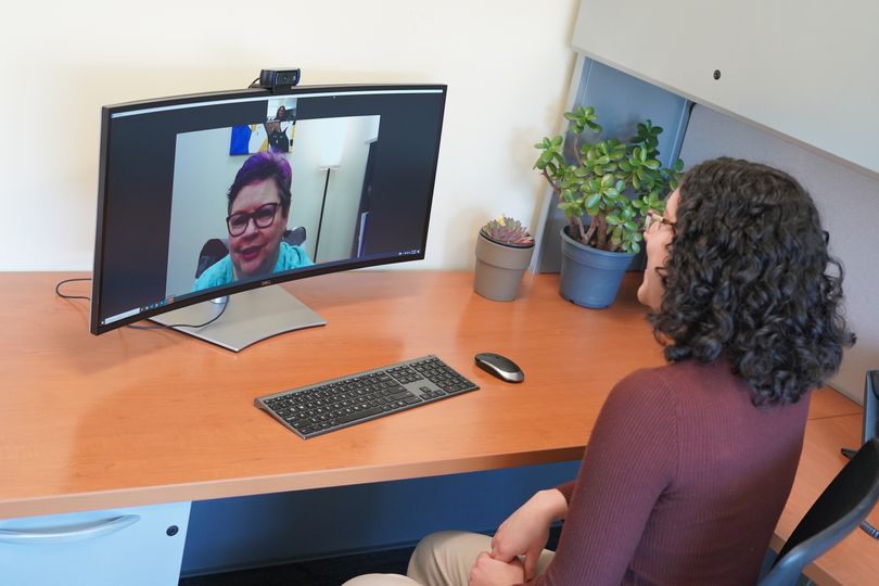 Photo of young woman speaking with older woman on computer screen.