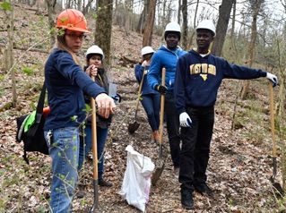 students working on a trail in the woods