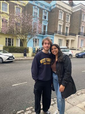 Photo of young man and young woman in front of townhouses.