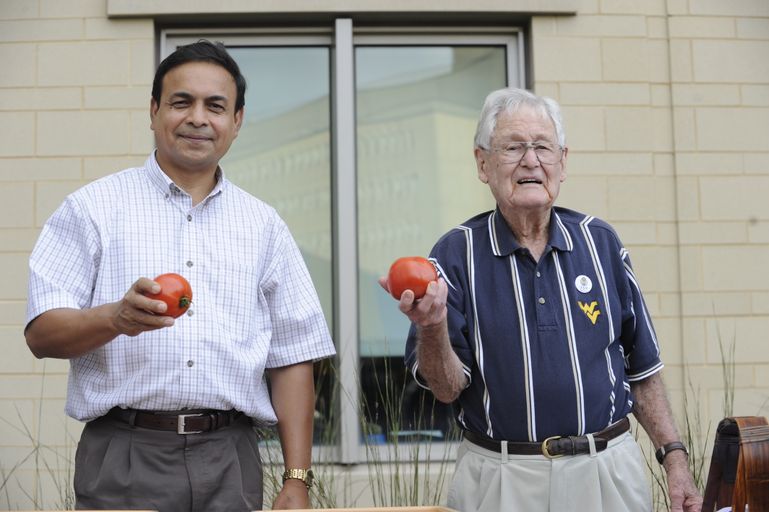 Mahfuz Rahman and Mannon Gallegly hold the new tomato varieties 