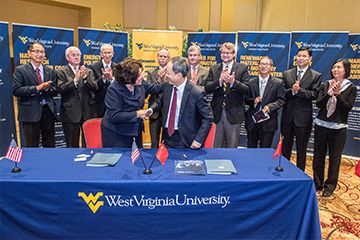 Provost Joyce McConnell shakes hands with Wang Shumin, senior vice president, Shenhua Energy Company, at a WVU signing ceremony in Morgantown, West Virginia.