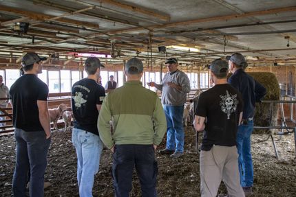 Photo of six men standing in barn