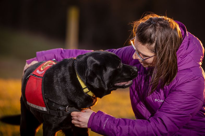 Photo of woman and service dog looking at each other